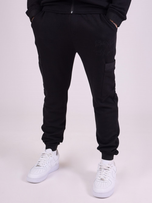 Jogging bottoms in textured fabric and sporty elastic details - Black